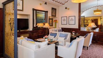 A hotel lobby with a seating area, a television, framed certificates, and decorative lamps.