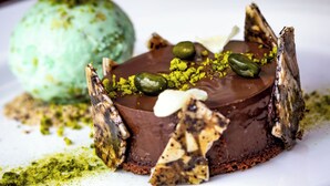 A dessert with a chocolate base, green pistachio pieces, and a mint scoop in the background. - Kilkenny Hibernian Hotel (Kilkenny)