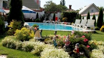 Relax by the pool surrounded by lush gardens and lounge chairs.