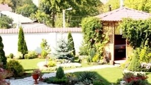 A garden with a stone pathway, potted plants, and a gazebo. - Edem Hotel (Chisinau)