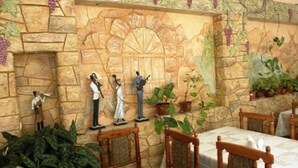 A dining area with stone walls, a mural, and several chairs and tables. - Edem Hotel (Chisinau)