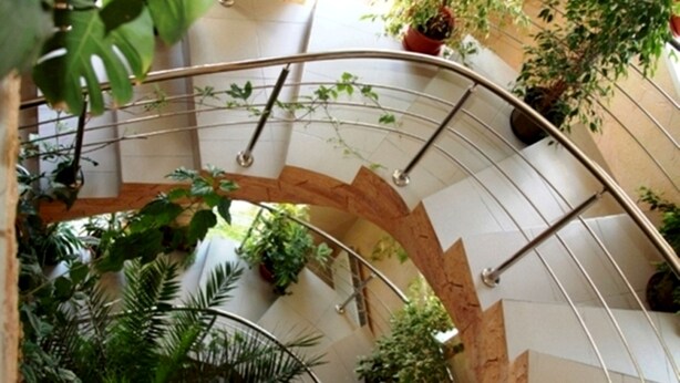 A spiral staircase with metal railings and potted plants. - Edem Hotel (Chisinau)