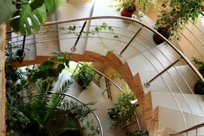 A spiral staircase with metal railings and potted plants. - Edem Hotel (Chisinau)