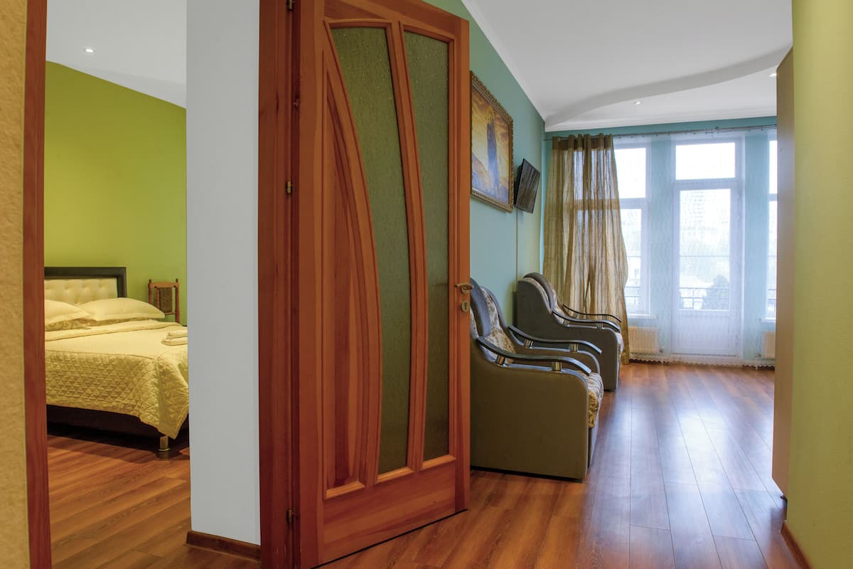 A room with a bed, a wooden wardrobe, a massage chair, and a window with curtains.