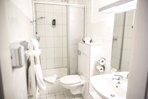 Un baño moderno con inodoro, bidé y ducha.