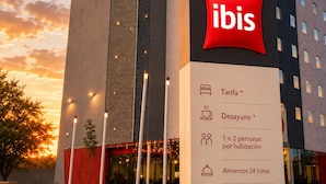 A modern hotel building with a prominent 'ibis' sign, indicating it is an ibis hotel.