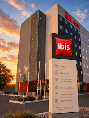 A modern hotel building with a prominent 'ibis' sign, indicating it is an ibis hotel.