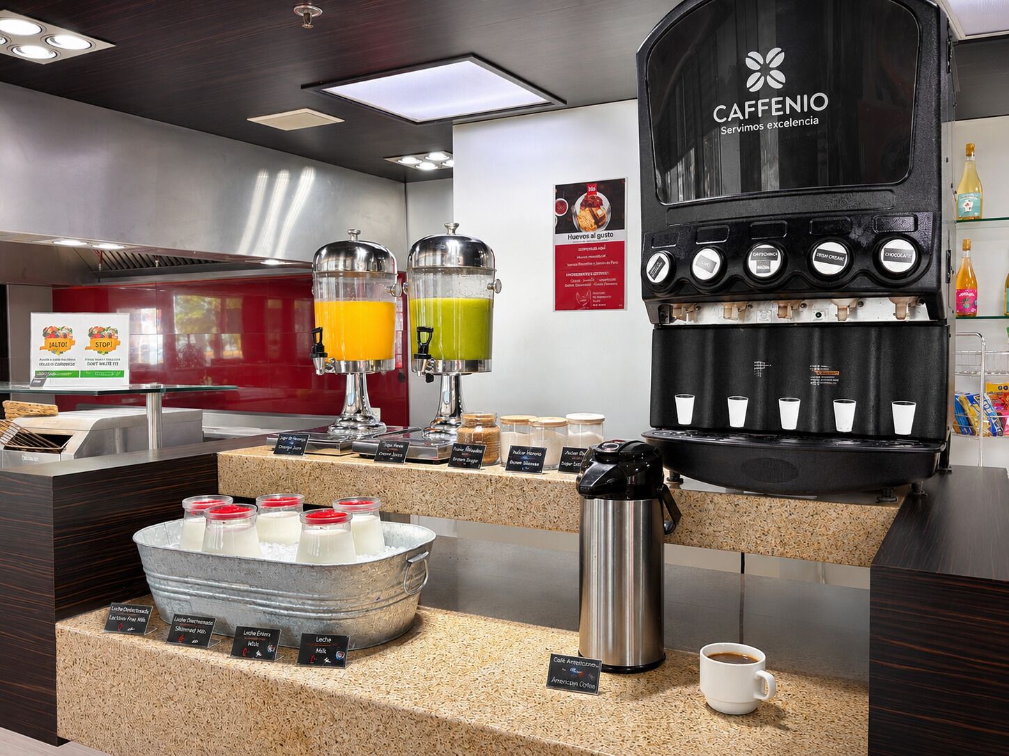 A café with a coffee machine, juice dispensers, and a milk station.