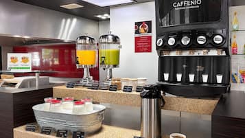 A café with a coffee machine, juice dispensers, and a milk station.
