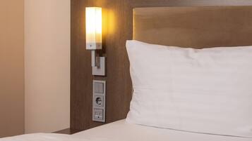 Ein Hotelzimmer mit einem Bett, einer Wandleuchte und einer Steckdose.