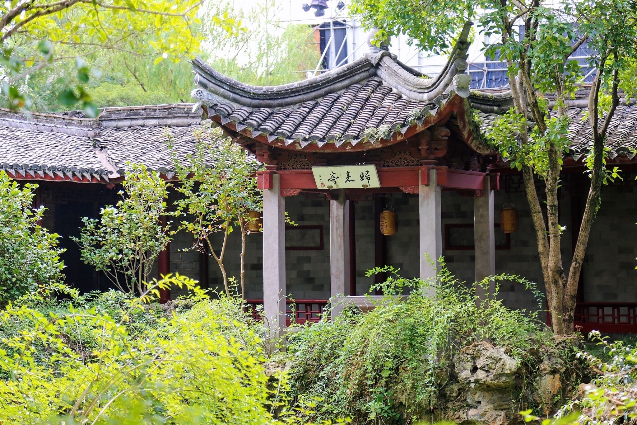 Un bâtiment traditionnel chinois, doté d’un toit recouvert de tuiles et d’une enseigne.