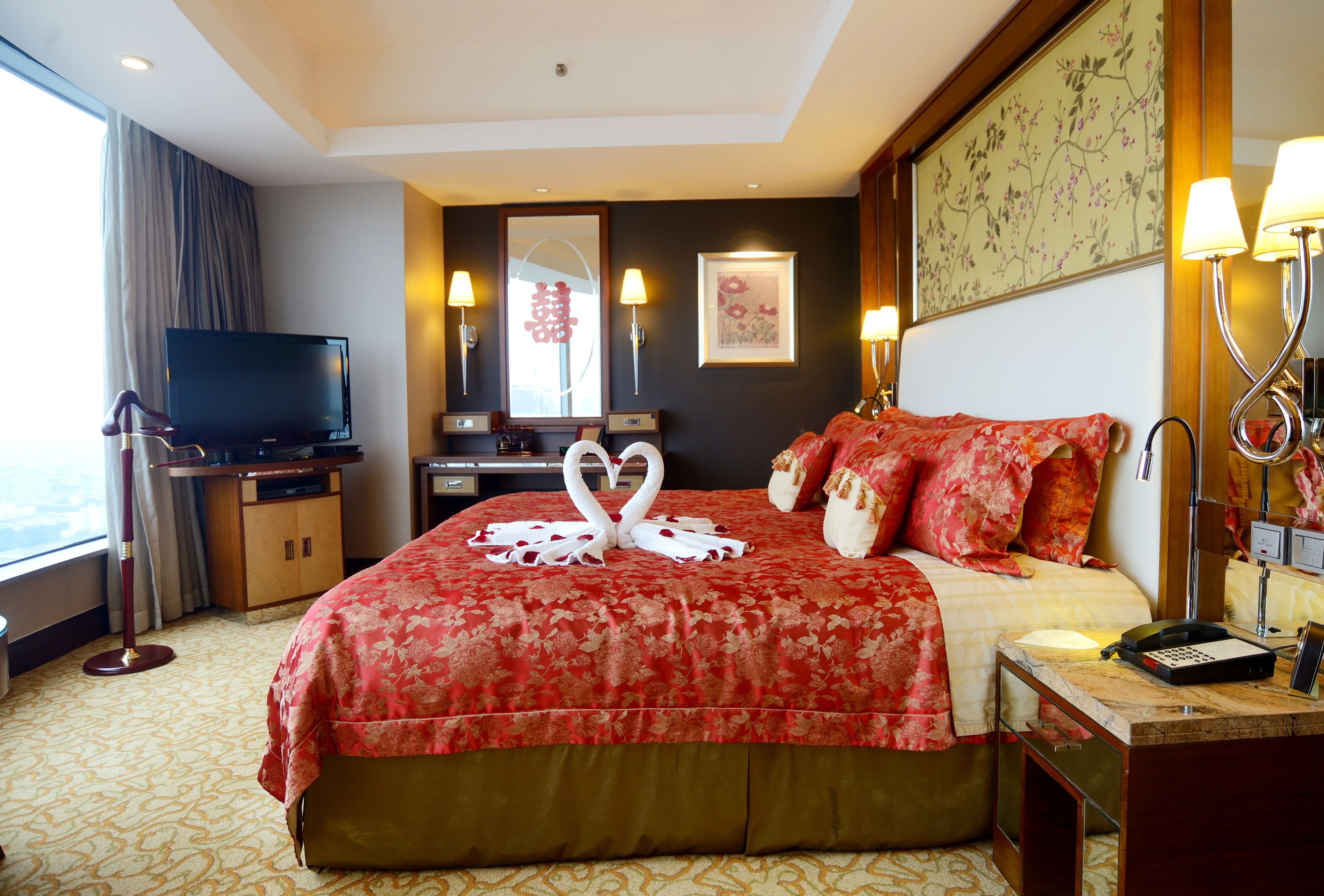 Una habitación de hotel con una cama grande, televisión, escritorio y baño.