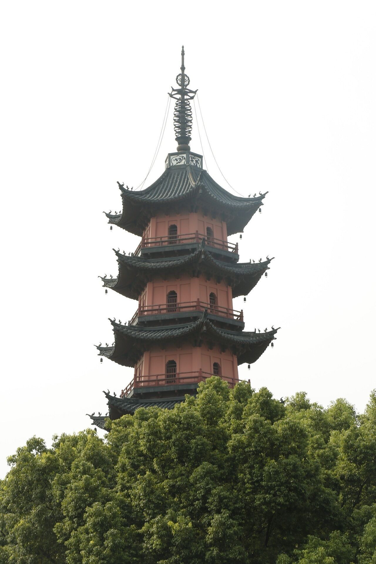 Eine mehrstufige Pagode mit traditioneller Architektur, umgeben von üppigem Grün.