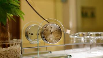 A clock on a clear stand with a blurred background.