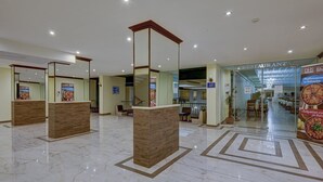 A hotel lobby with a marble floor, reception desks, and a restaurant in the background. - Shipka (Golden Sands)