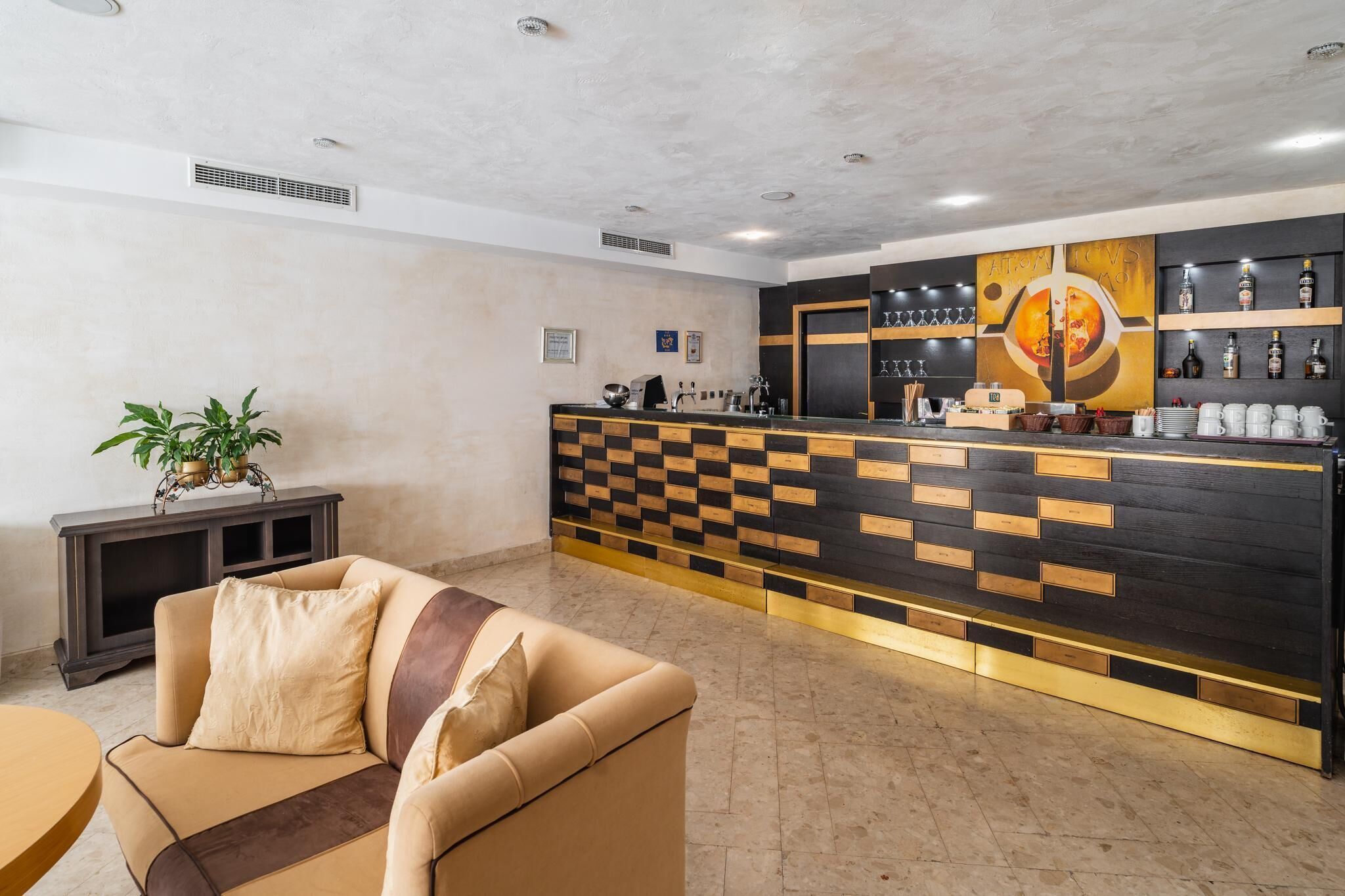 A reception area with a checkered counter, a sofa, and a potted plant.
