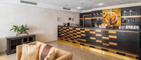 A reception area with a checkered counter, a sofa, and a potted plant.