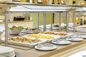 A buffet with various food options including salads, fried foods, and pasta.