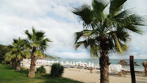 A beach with palm trees, beach umbrellas, and a view of the sea. - Royal Park Hotel - All Inclusive (Elenite)