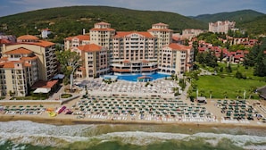 A hotel with a large pool, multiple balconies, and a beach area with sun loungers. - Royal Park Hotel - All Inclusive (Elenite)