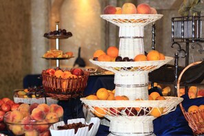A fruit display with multiple wicker stands and baskets containing various fruits.