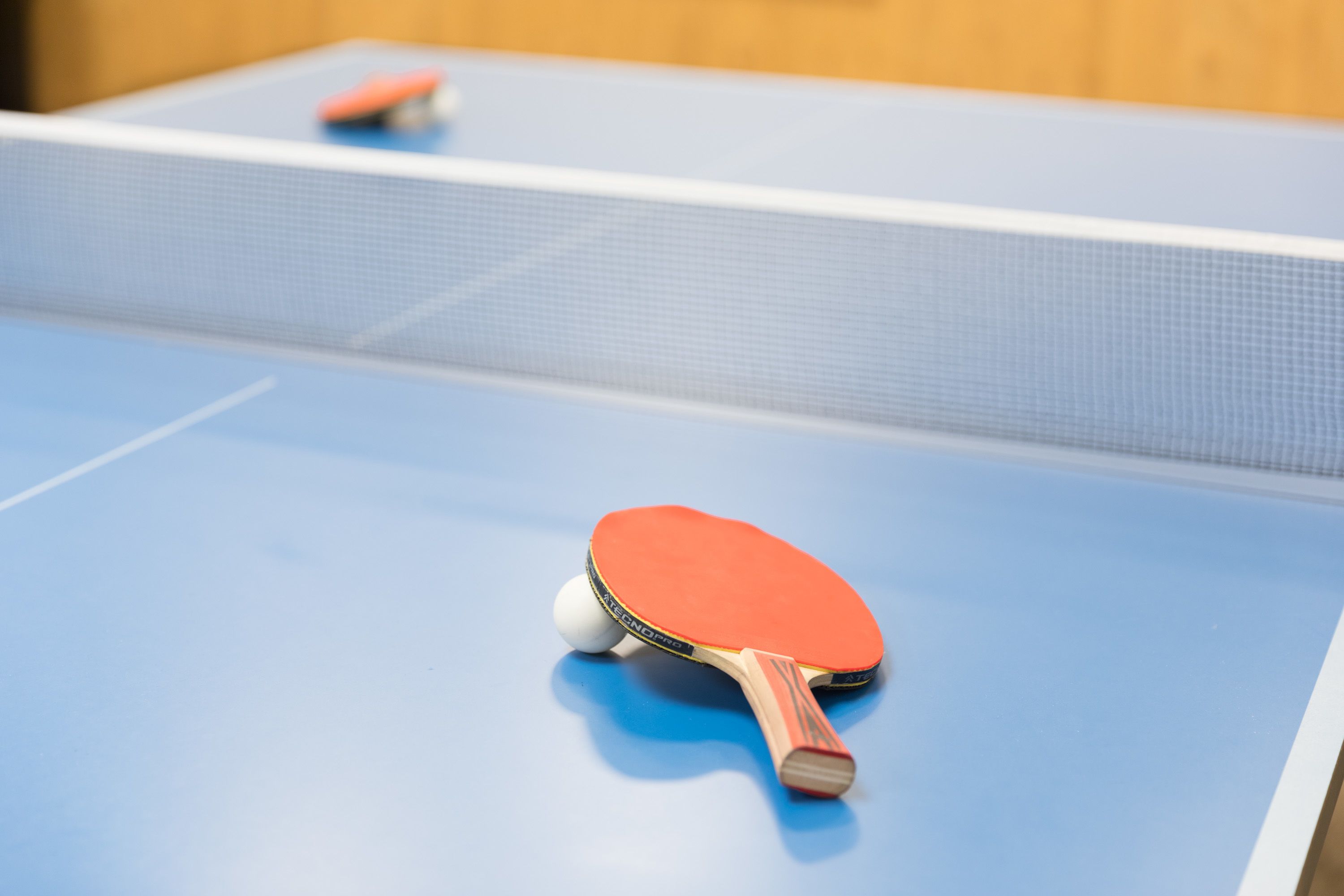 A table tennis table with a blue surface and a net.