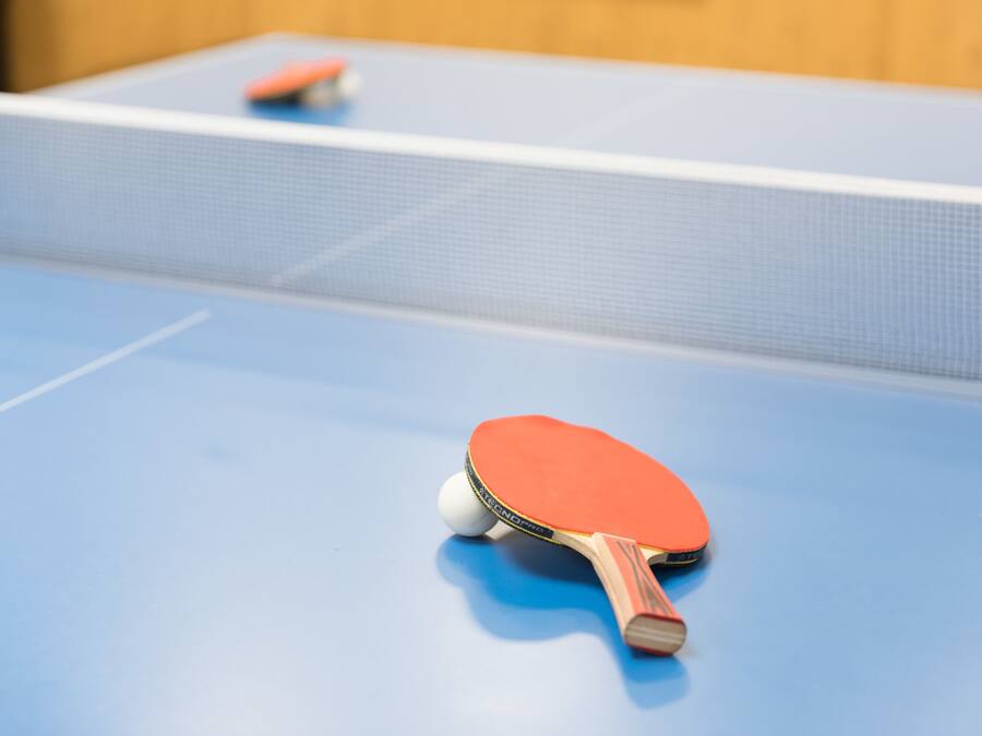 A table tennis table with a blue surface and a net.