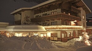 Un edificio cubierto de nieve con varios balcones e iluminación exterior.