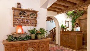 Un mostrador de recepción de madera con una planta, un escurridor decorativo y una vela encendida.