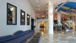 A spacious lobby with a blue sofa, a reception desk, and a staircase. - Astera Hotel & Spa (Golden Sands)