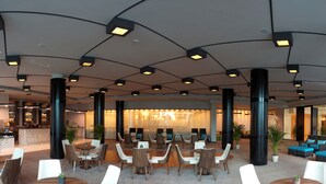 A spacious lobby with multiple seating areas, a reception desk, and a bar. - Astera Hotel & Spa (Golden Sands)