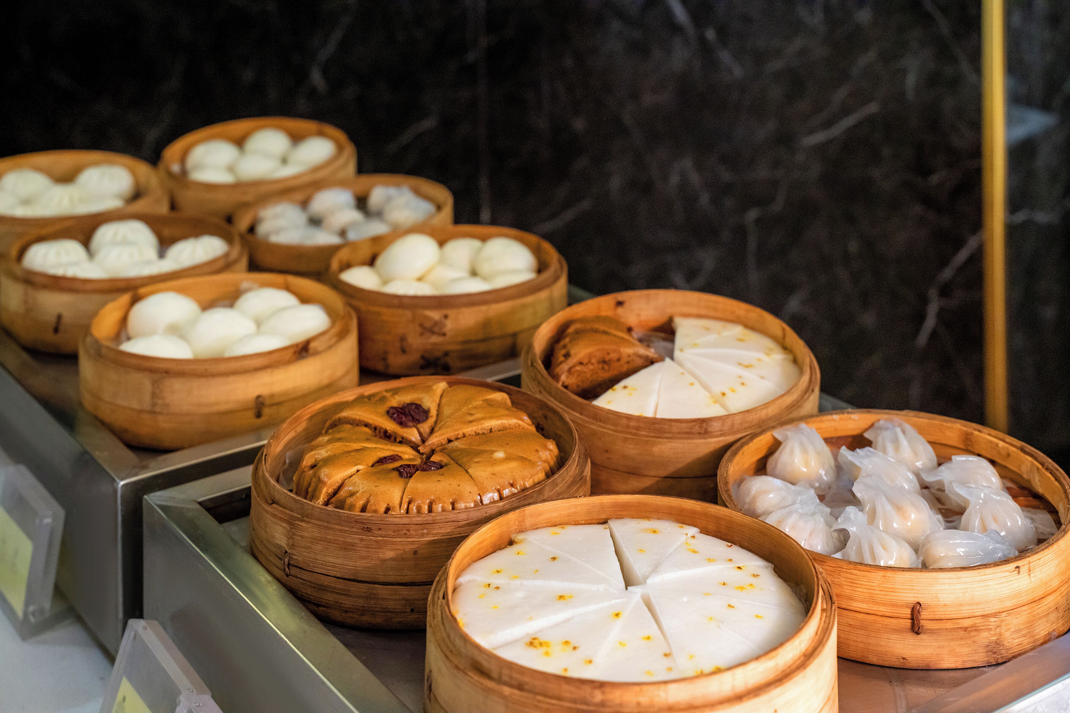 Diverse dim sum gerechten gepresenteerd in houten manden.