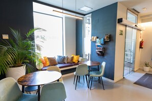 A modern interior with a seating area, a table, and a bookshelf. - Urban Sea Atocha 113 (Madrid)