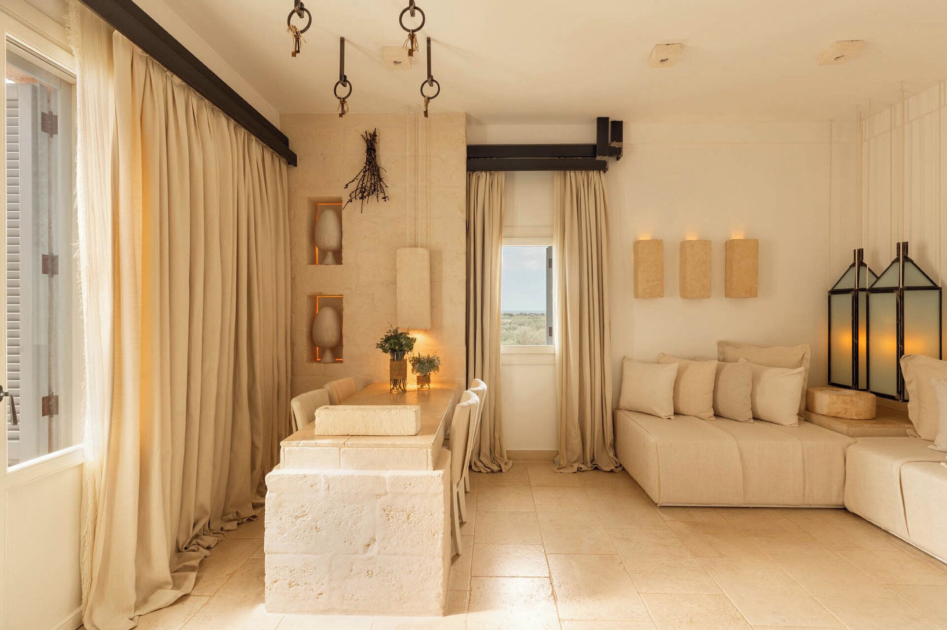 Un salón amplio con un sofá color beige, una mesa de comedor con sillas y un adorno decorativo.