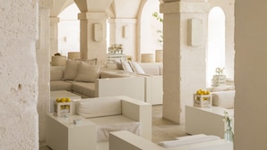A spacious, modern interior with a minimalist design, featuring a large seating area and a well-lit, open space with arches. - Borgo Egnazia (Fasano)