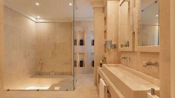 Une salle de bain moderne avec une douche à parois de verre, une grande baignoire et un meuble-lavabo avec un miroir.