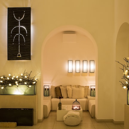 A well-lit, modern living room with a sofa set, decorative lighting, and a unique wall art piece.