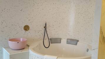Une salle de bain moderne avec une baignoire sur pieds, un lavabo rose et un sol en marbre.