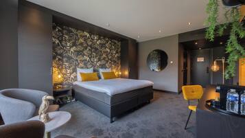 A modern bedroom with a large bed, a desk, and a chair.