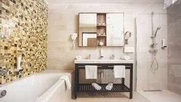A modern bathroom with a bathtub, a vanity with a mirror, and a shower area.