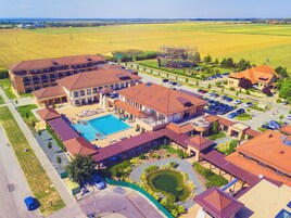 Vista aérea de un hotel con piscina, varias edificaciones y estacionamiento.