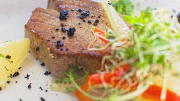 Primer plano de un bistec con pimienta negra y una ensalada al lado.