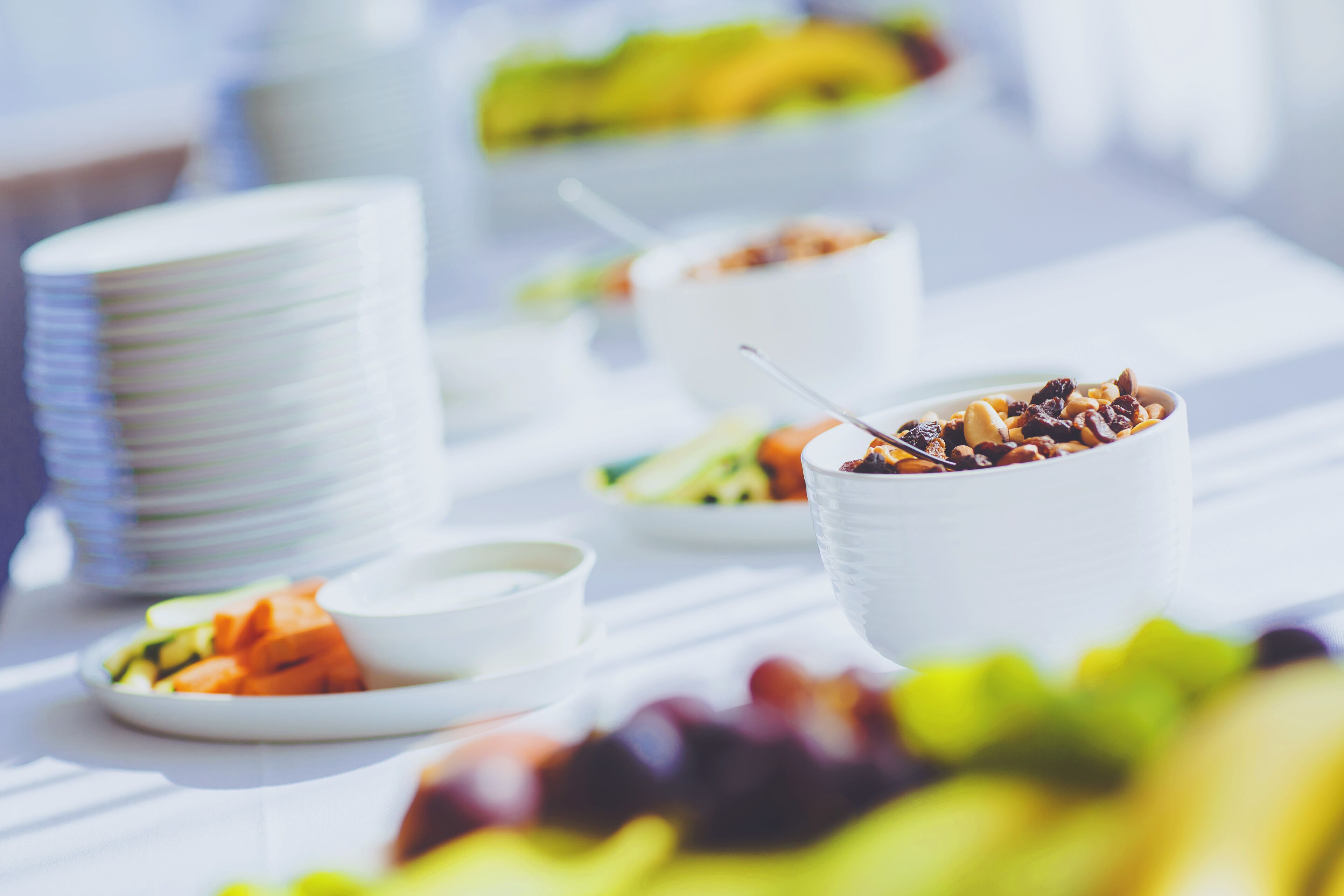 A buffet table with various dishes and bowls of food.