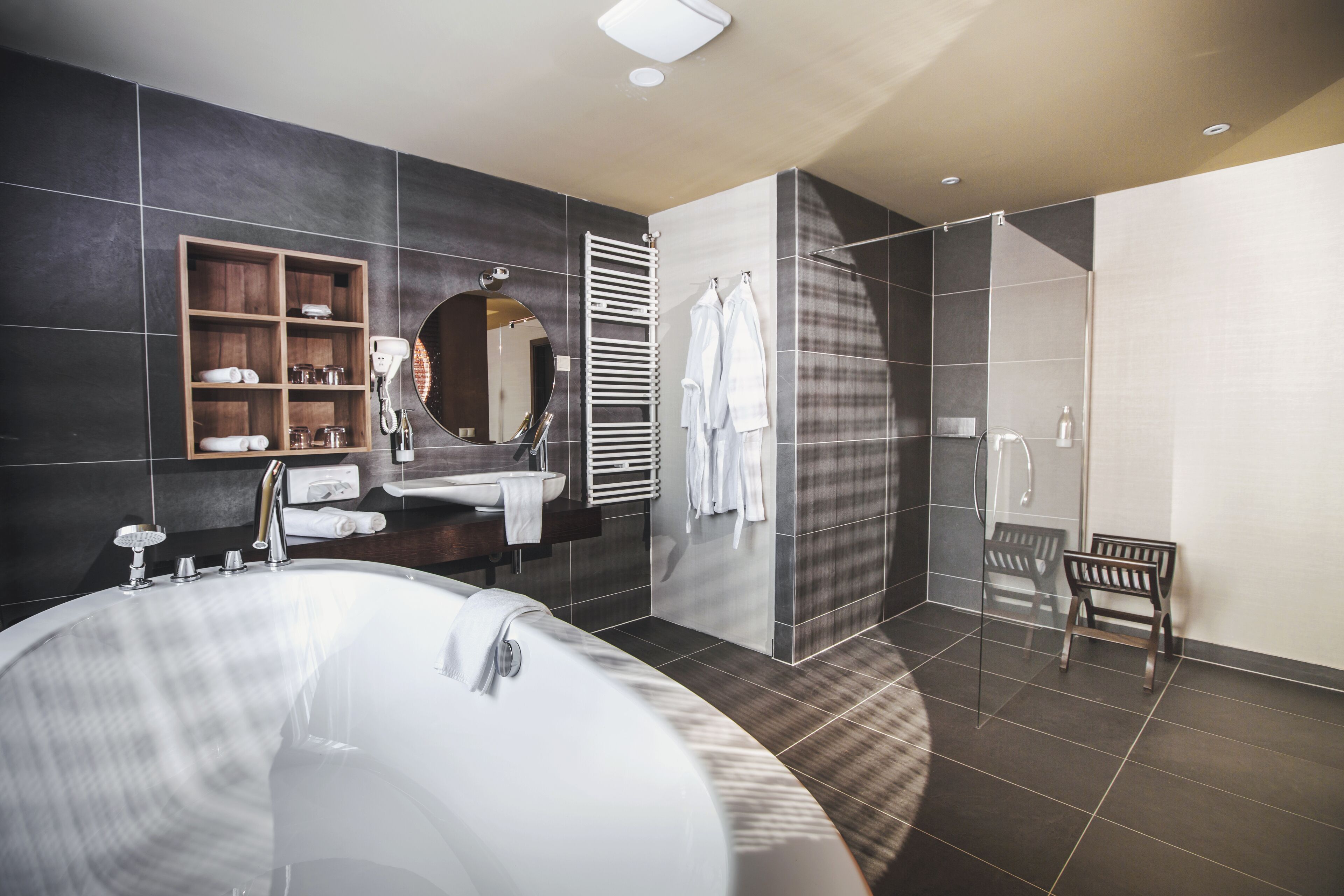 Ein modernes Badezimmer mit einer großen Badewanne, einem Holzbadezimmer, einem Spiegel und einer Duschkabine.