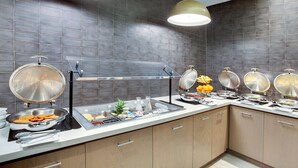 Eine moderne Küche mit grauen Fliesenwänden, Edelstahlgeräten und Holzschränken.