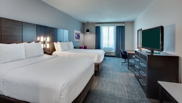 A hotel room with two beds, a desk, a television, and a window with curtains. - Crowne Plaza Hotel Fort Lauderdale Airport/Cruiseport by IHG (Fort Lauderdale)