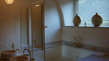 Relax in a spacious bathroom with a bathtub and glass-enclosed shower.