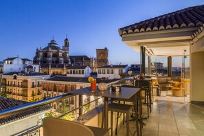 A rooftop terrace with a bar area, a view of historic buildings, and a glass railing. - Eurostars Gran Vía Hotel (Granada)