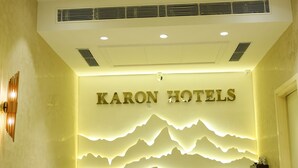 Eine Rezeption mit einem Chandelier und einem an der Wand befestigten Schild für Karon Hotels.