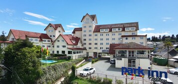 Un hotel con varias edificaciones, piscina y zona de estacionamiento.